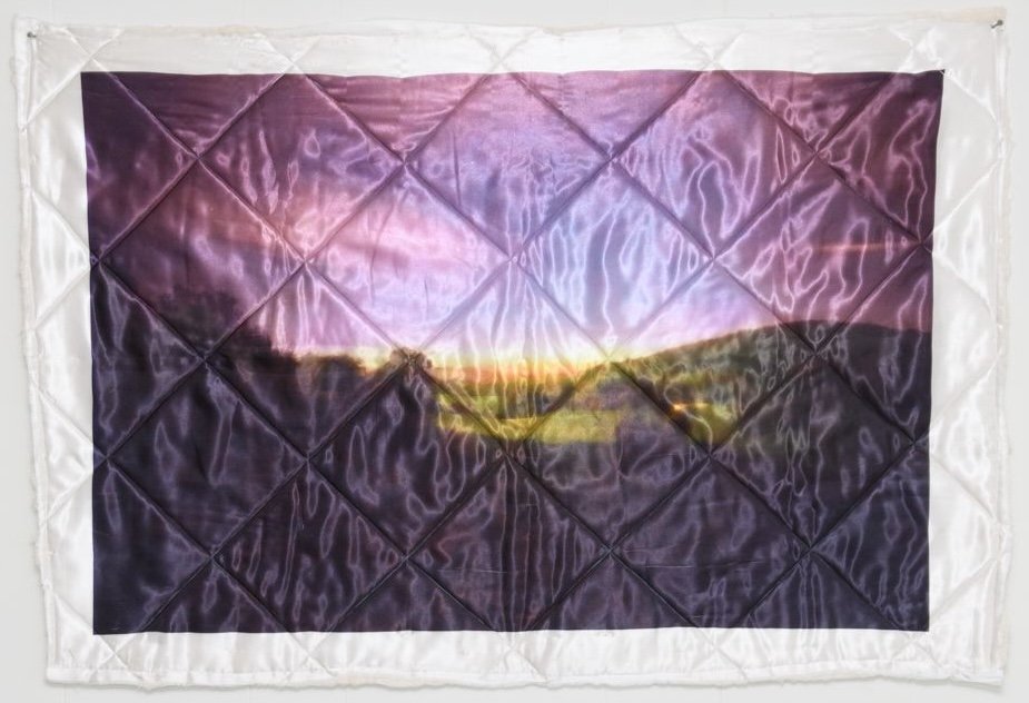 Photograph of a rural landscape printed on an artist-made quilt.