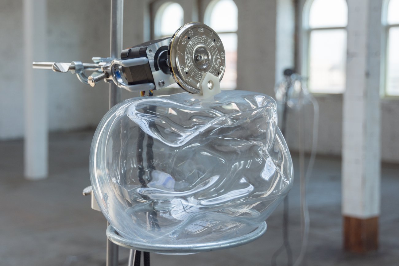 Closeup of pitch pipe device, which includes smushed glass globe and metal mechanics