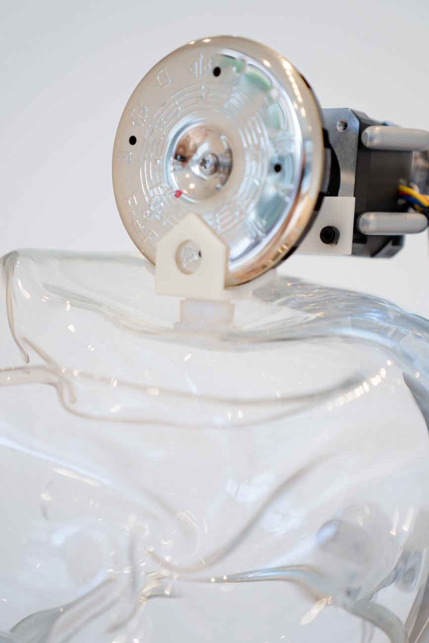 Closeup of a metal tuner atop a glass orb.