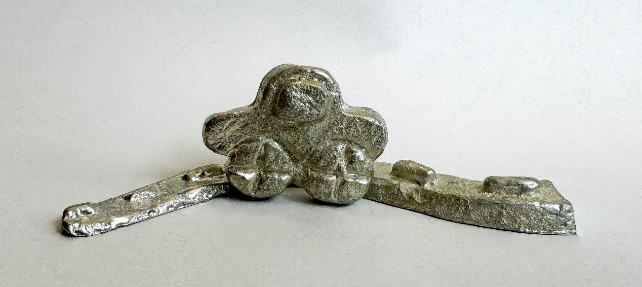 A miniature cast metal car on a metal track resembling a road