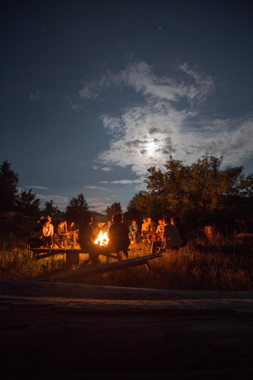 Group of artists gathered around bonfire 