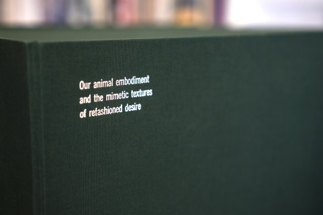 Detail of the upper left corner of the book box with text that reads "Our animal embodiment and the mimetic textures of refashioned desire"